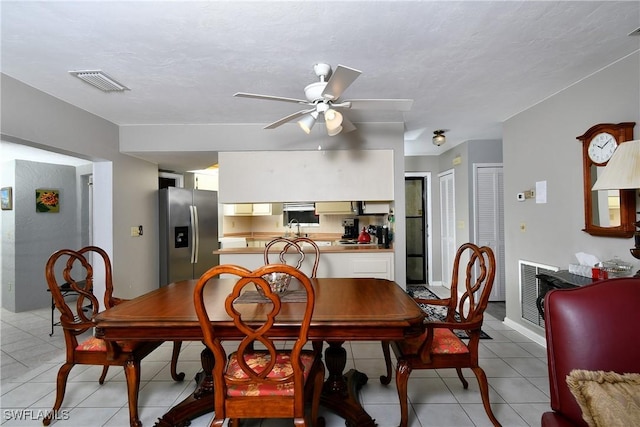 tiled dining room featuring ceiling fan and sink