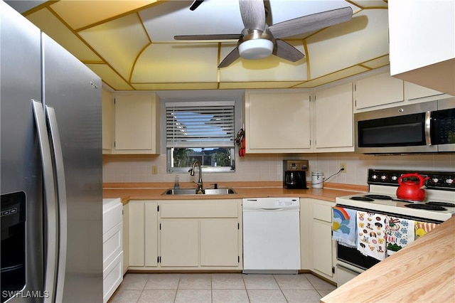 kitchen featuring backsplash, light tile patterned floors, sink, and appliances with stainless steel finishes