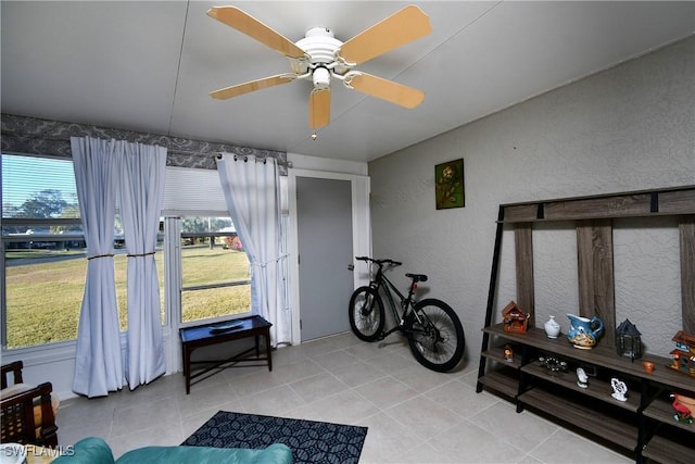 living area featuring ceiling fan and light tile patterned floors