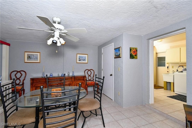 tiled dining area featuring ceiling fan, sink, a textured ceiling, and washer / dryer