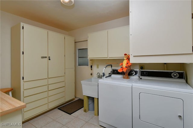 laundry room with separate washer and dryer, light tile patterned floors, and cabinets