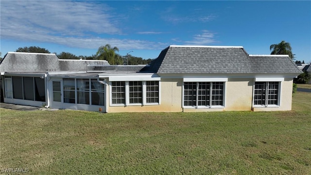 back of property featuring a lawn and a sunroom