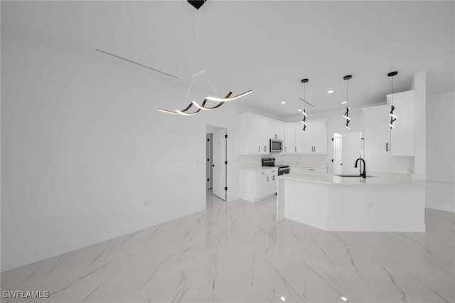 kitchen with white cabinetry, sink, kitchen peninsula, decorative light fixtures, and appliances with stainless steel finishes