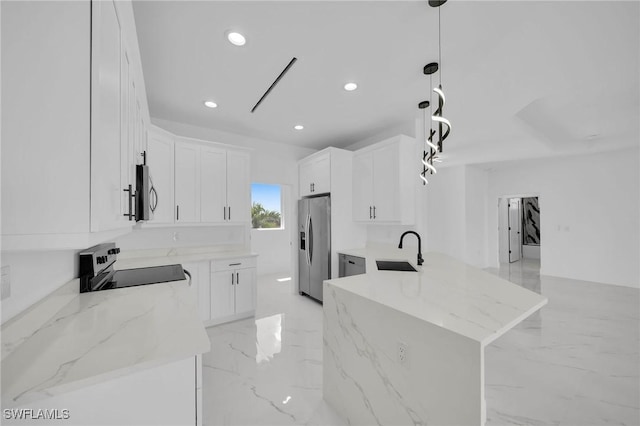 kitchen with light stone countertops, stainless steel fridge, sink, pendant lighting, and white cabinets