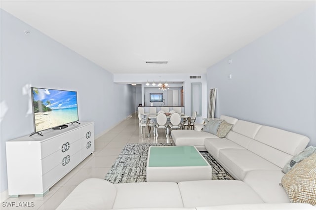 living room with light tile patterned flooring and an inviting chandelier