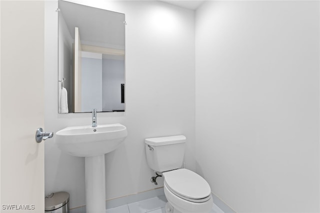 bathroom featuring tile patterned flooring, toilet, and sink