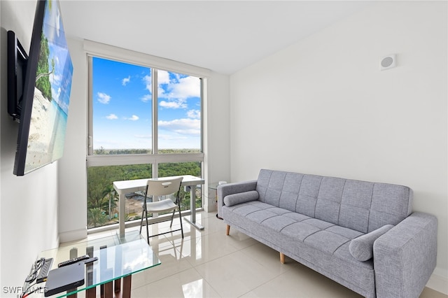 living room featuring a healthy amount of sunlight, a wall of windows, and light tile patterned floors