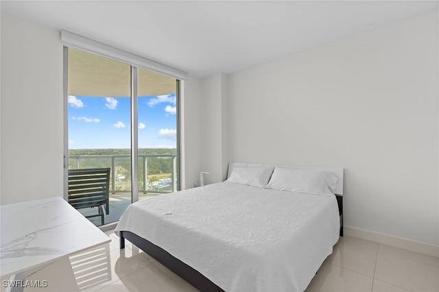 tiled bedroom with a wall of windows and access to outside