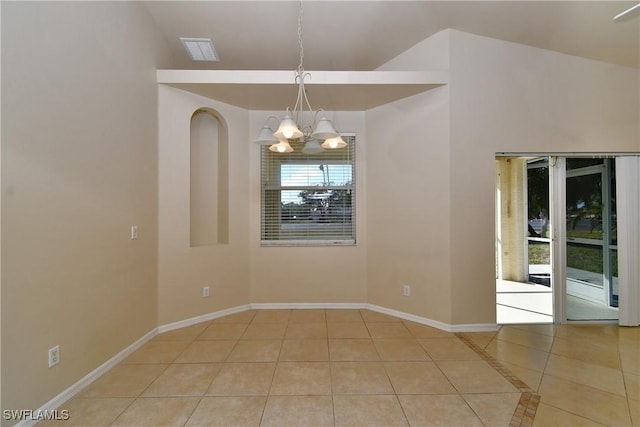 tiled empty room with vaulted ceiling and a chandelier