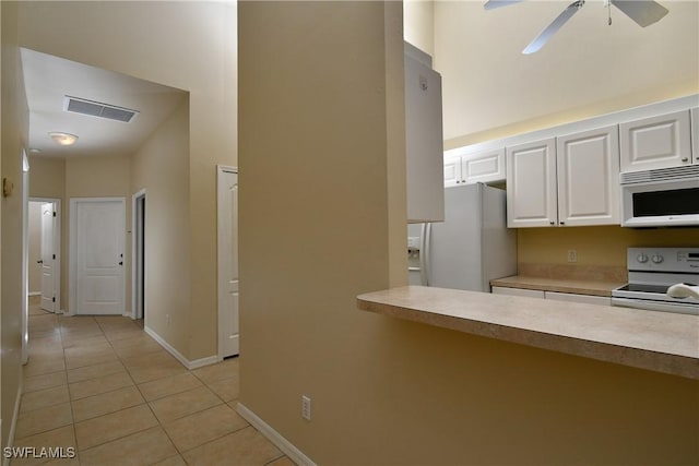 kitchen featuring white cabinetry, light tile patterned flooring, white appliances, and ceiling fan