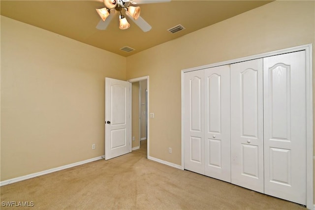 unfurnished bedroom with ceiling fan, light colored carpet, and a closet