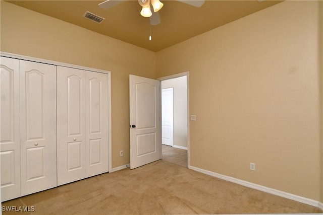 unfurnished bedroom featuring light carpet, a closet, and ceiling fan