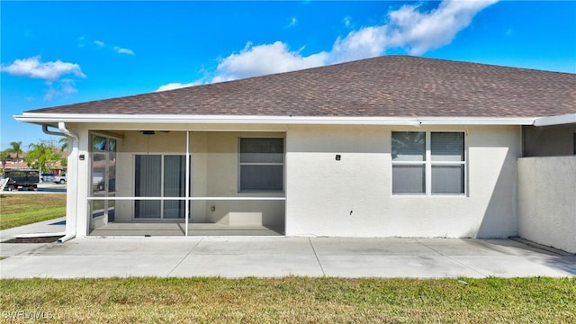 back of property with a sunroom and a patio