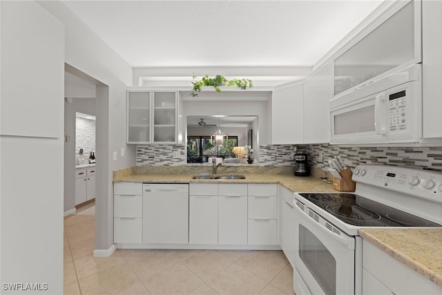 kitchen with white cabinets, decorative backsplash, white appliances, and sink