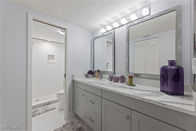 bathroom featuring tile patterned floors, vanity, toilet, and walk in shower