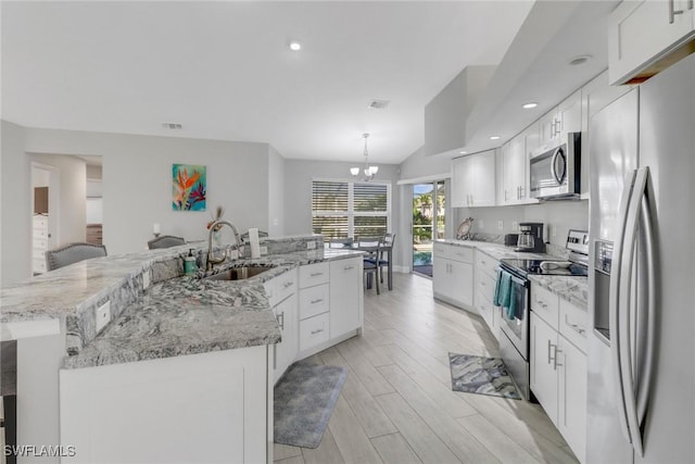 kitchen with a large island with sink, sink, light hardwood / wood-style flooring, appliances with stainless steel finishes, and white cabinetry