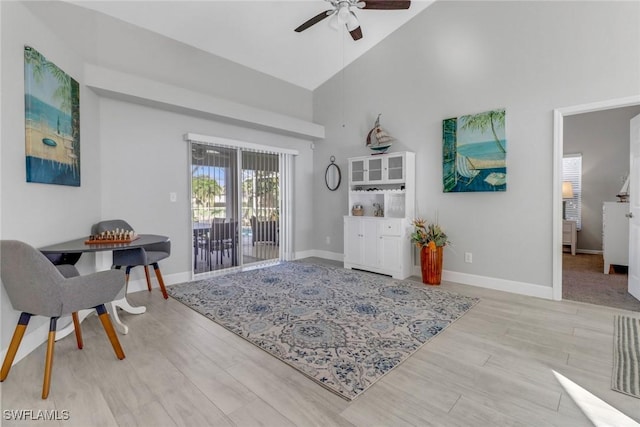 interior space with ceiling fan, light hardwood / wood-style flooring, and high vaulted ceiling