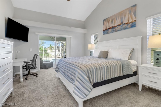 carpeted bedroom featuring access to outside, vaulted ceiling, and multiple windows