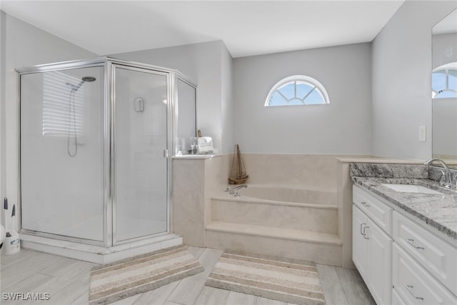 bathroom featuring vanity, wood-type flooring, and shower with separate bathtub