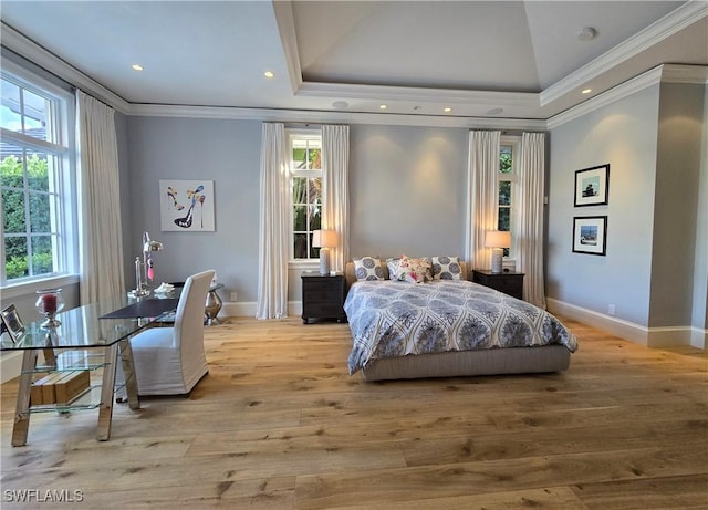 bedroom with ornamental molding, a raised ceiling, and light wood-style flooring