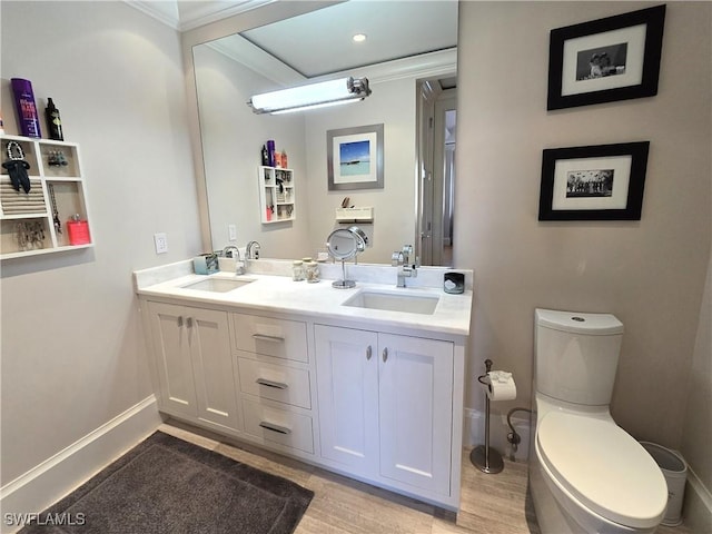 full bath with double vanity, a sink, toilet, and baseboards