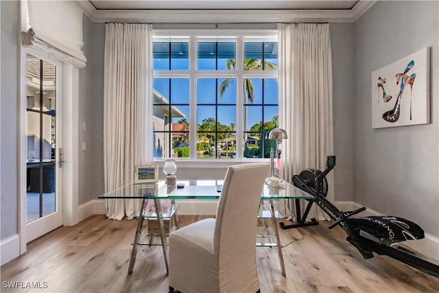 dining space with baseboards, ornamental molding, and wood finished floors