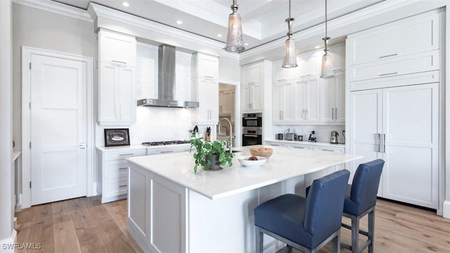 kitchen with white cabinets, wall chimney exhaust hood, light countertops, and stainless steel double oven