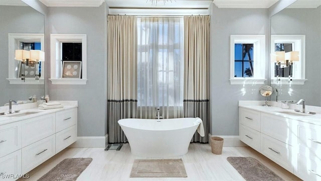 bathroom with a soaking tub, two vanities, and a sink