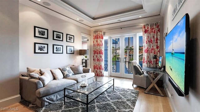 living room with a raised ceiling, crown molding, french doors, and wood finished floors