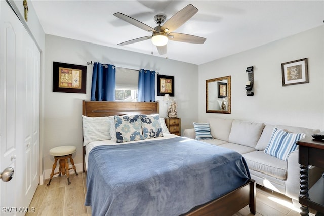 bedroom featuring a ceiling fan, wood finished floors, a closet, and baseboards