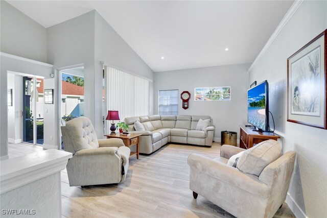 living room featuring crown molding, high vaulted ceiling, and light hardwood / wood-style floors