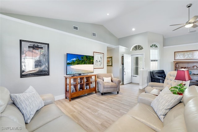 living room featuring lofted ceiling, light wood-style floors, visible vents, and baseboards