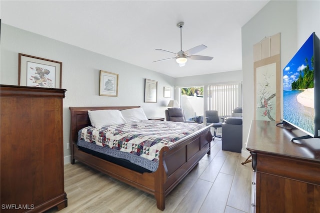 bedroom featuring a ceiling fan, vaulted ceiling, and light wood-style floors