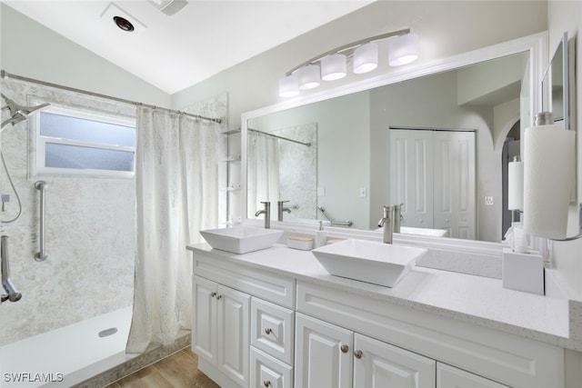 bathroom with lofted ceiling, a shower with curtain, and a sink