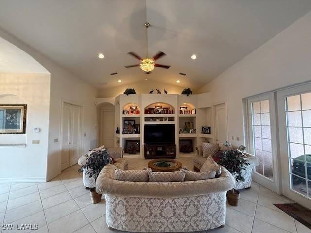 living room with built in shelves, ceiling fan, light tile patterned floors, and vaulted ceiling