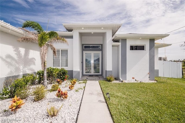 view of exterior entry featuring a lawn