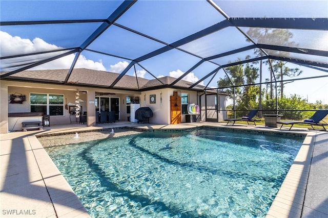 view of pool with a lanai, ceiling fan, and a patio