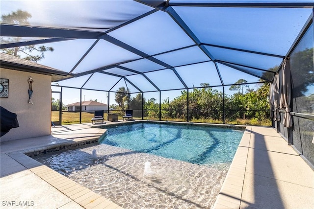 view of pool with glass enclosure and a patio