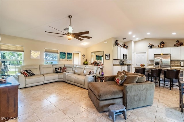 living room featuring ceiling fan, light tile patterned flooring, and lofted ceiling