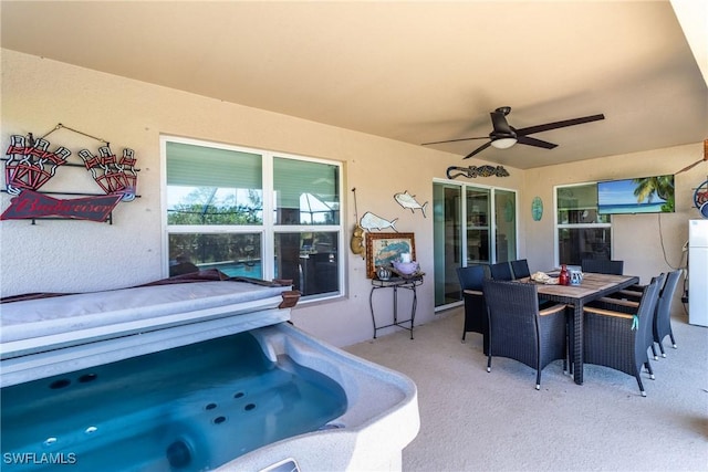 view of patio / terrace featuring ceiling fan and a hot tub