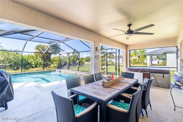 view of swimming pool featuring ceiling fan, a lanai, a patio, and a hot tub