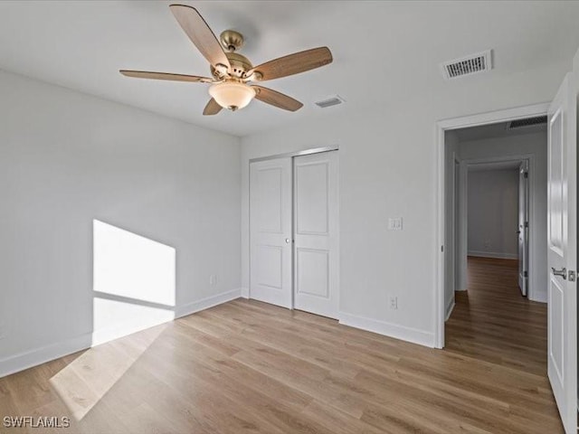 unfurnished bedroom featuring light hardwood / wood-style floors, a closet, and ceiling fan