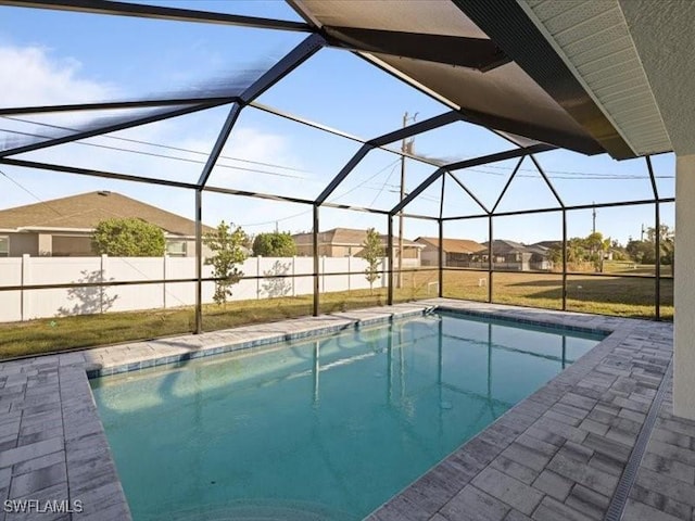 view of swimming pool featuring a patio area, a lanai, and a lawn