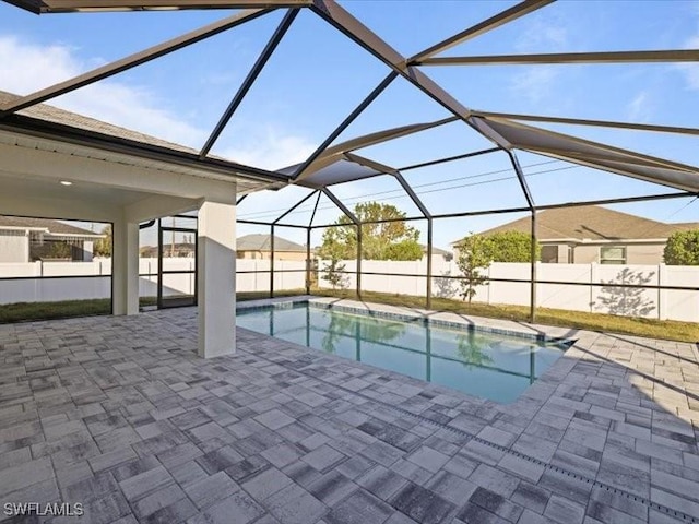 view of swimming pool featuring a patio and a lanai