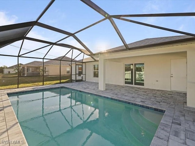 view of pool with glass enclosure and a patio area