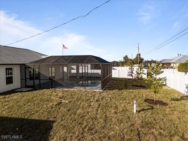 view of yard featuring a fenced in pool and glass enclosure