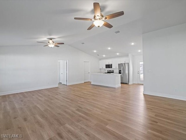 unfurnished living room featuring ceiling fan, light hardwood / wood-style floors, and vaulted ceiling