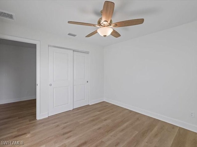 unfurnished bedroom with ceiling fan, a closet, and light wood-type flooring