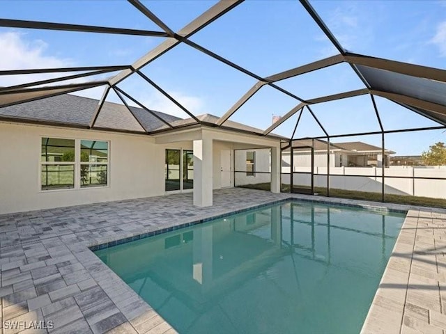 view of swimming pool featuring glass enclosure and a patio