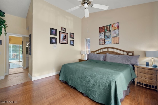 bedroom with wood-type flooring, high vaulted ceiling, and ceiling fan